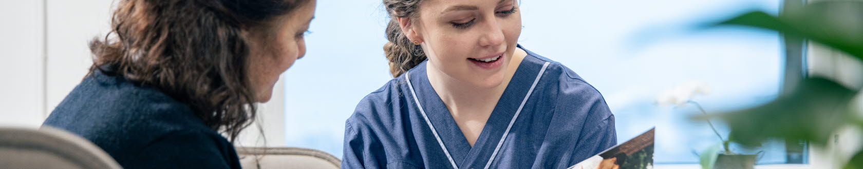 En sjuksköterska visar en bok för en patient. Foto: Yanan Li