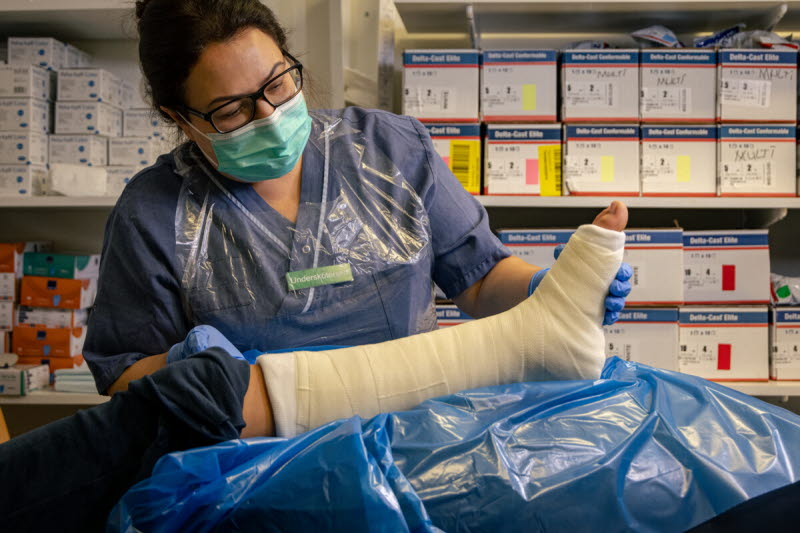 Undersköterska på närakut gipsar benet på en patient. Foto: Yanan Li