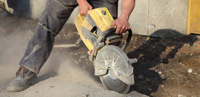 Byggarbetare med betongskärmaskin.