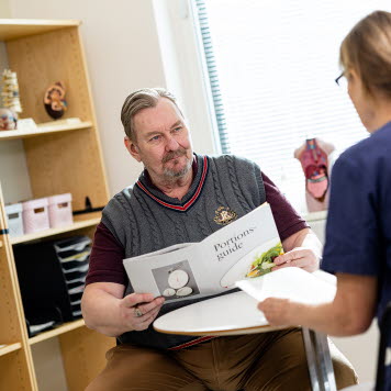 En vårdpersonal går igenom en broschyr om mat med en patient som har obesitas. Foto: Yanan Li