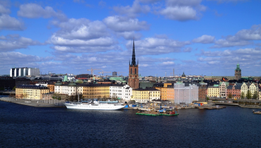 Vy över Stockholm en solig dag, blå himmel med vita moln.