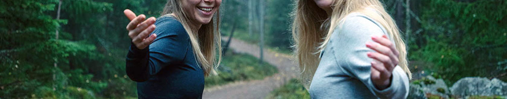 Två unga kvinnor på skogspromenad