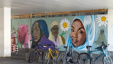 Väggmålning i tunnel, parkerade cyklar i förgrunden.