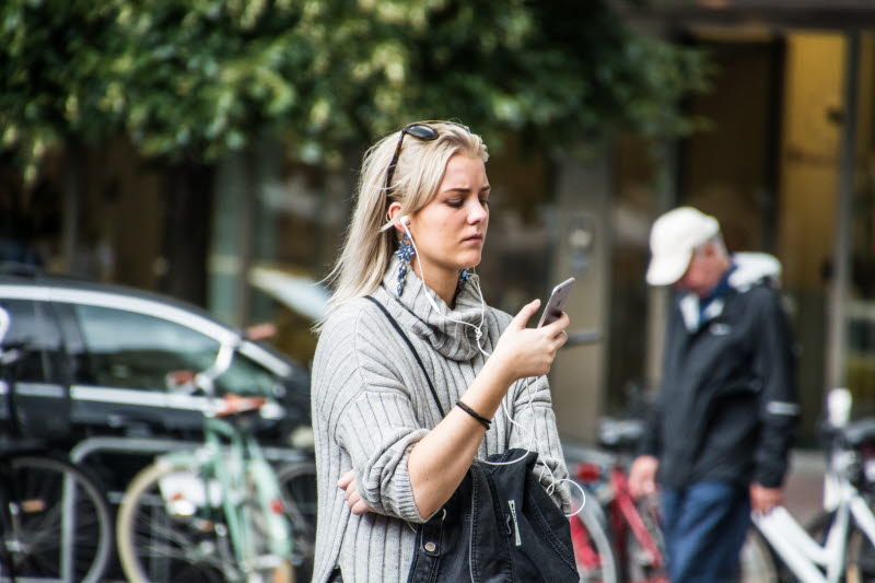 Kvinna tittar på mobiltelefon