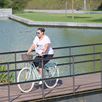 En ung person cyklar längs en flod. Foto: ECPO Media