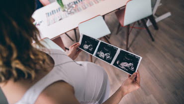 Gravid kvinna tittar på ultraljudsbild