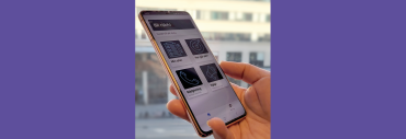 en hand håller i en mobiltelefon