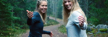 Två unga kvinnor på skogspromenad