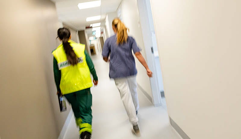 Sjukvårdspersonal som skyndar fram genom sjukhuskorridor nattetid.