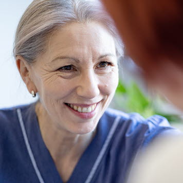 En vårdpersonal ler mot en patient. Foto: Yanan Li