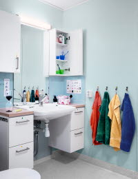Ett badrum med hjälpmedel som kan förenkla vardagen. Till exempel har varje familjemedlem varsin färg på handduk och tandborste. 