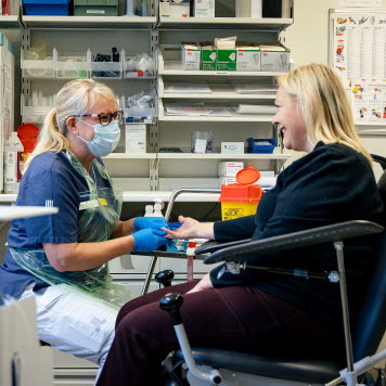 En sjuksköterska tar blodprov från fingret på en patient. Foto: Yanan Li